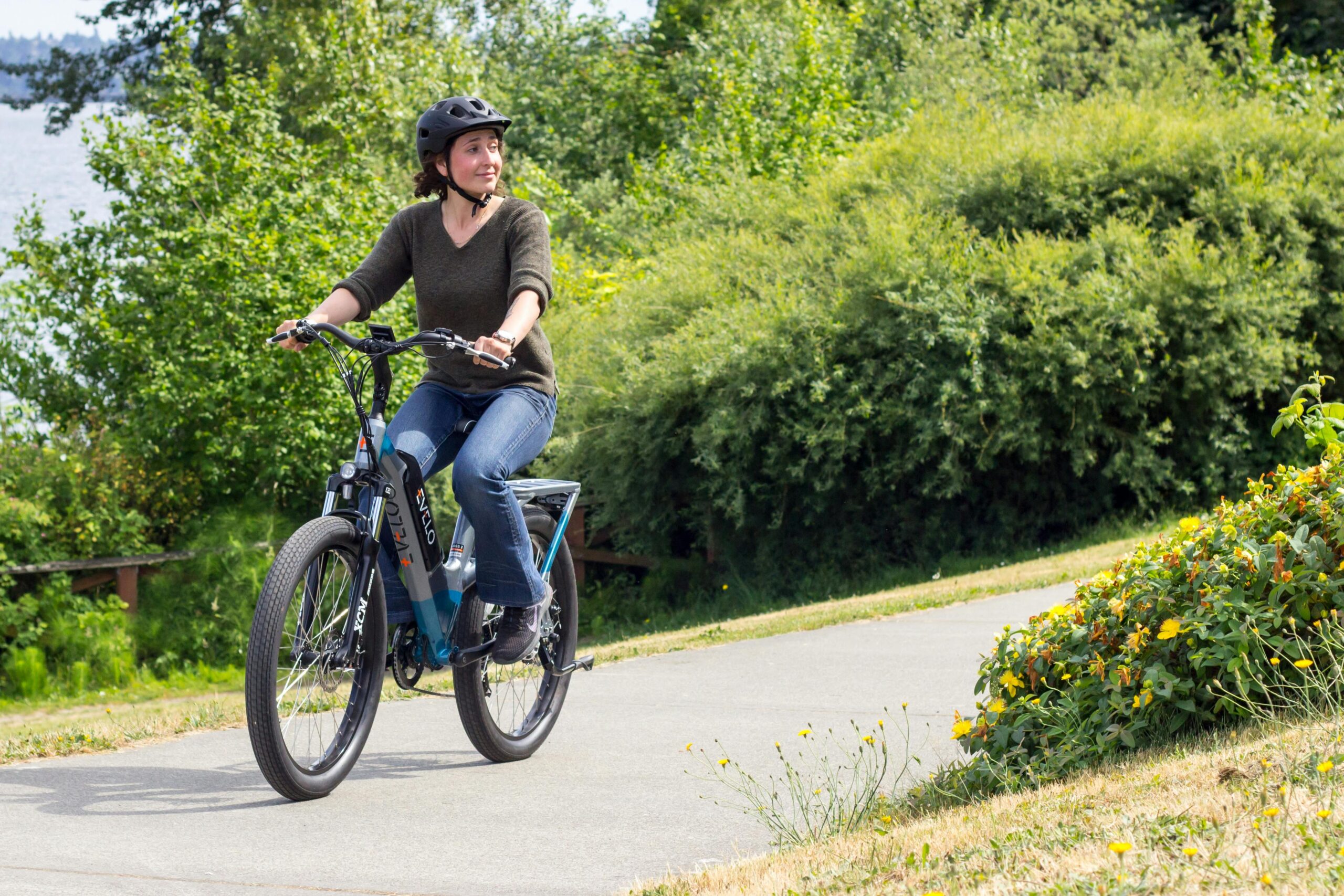 A woman riding an electric bike on a paved path